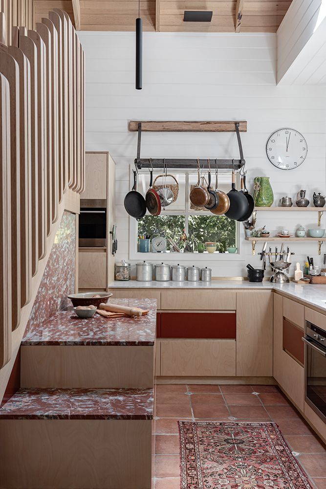 Kitchen with Red-Tiled Steps, Light Timber Cabinets, and Hanging Pots — BSpoke Cabinet Making & Joinery in Unanderra, NSW