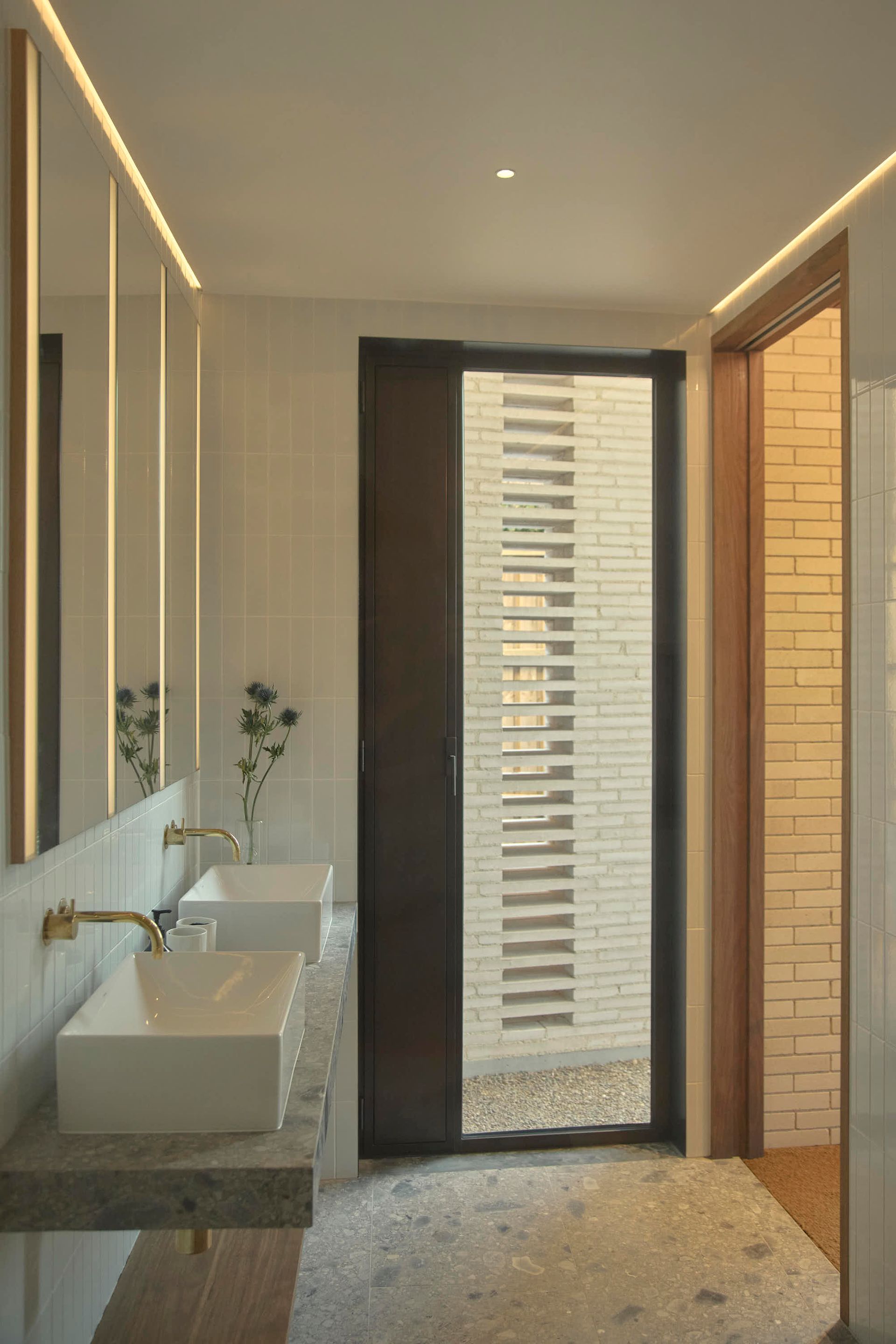 Modern bathroom with two sinks, a brick door, and decorative lighting — BSpoke Cabinet Making & Joinery in Shellharbour, NSW