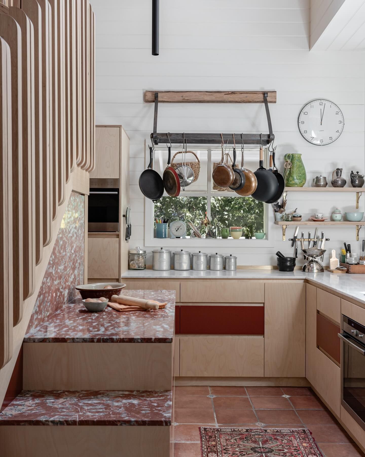 A Kitchen with Orange Tiles and Hanging Pans— BSpoke Cabinet Making & Joinery in Unanderra, NSW