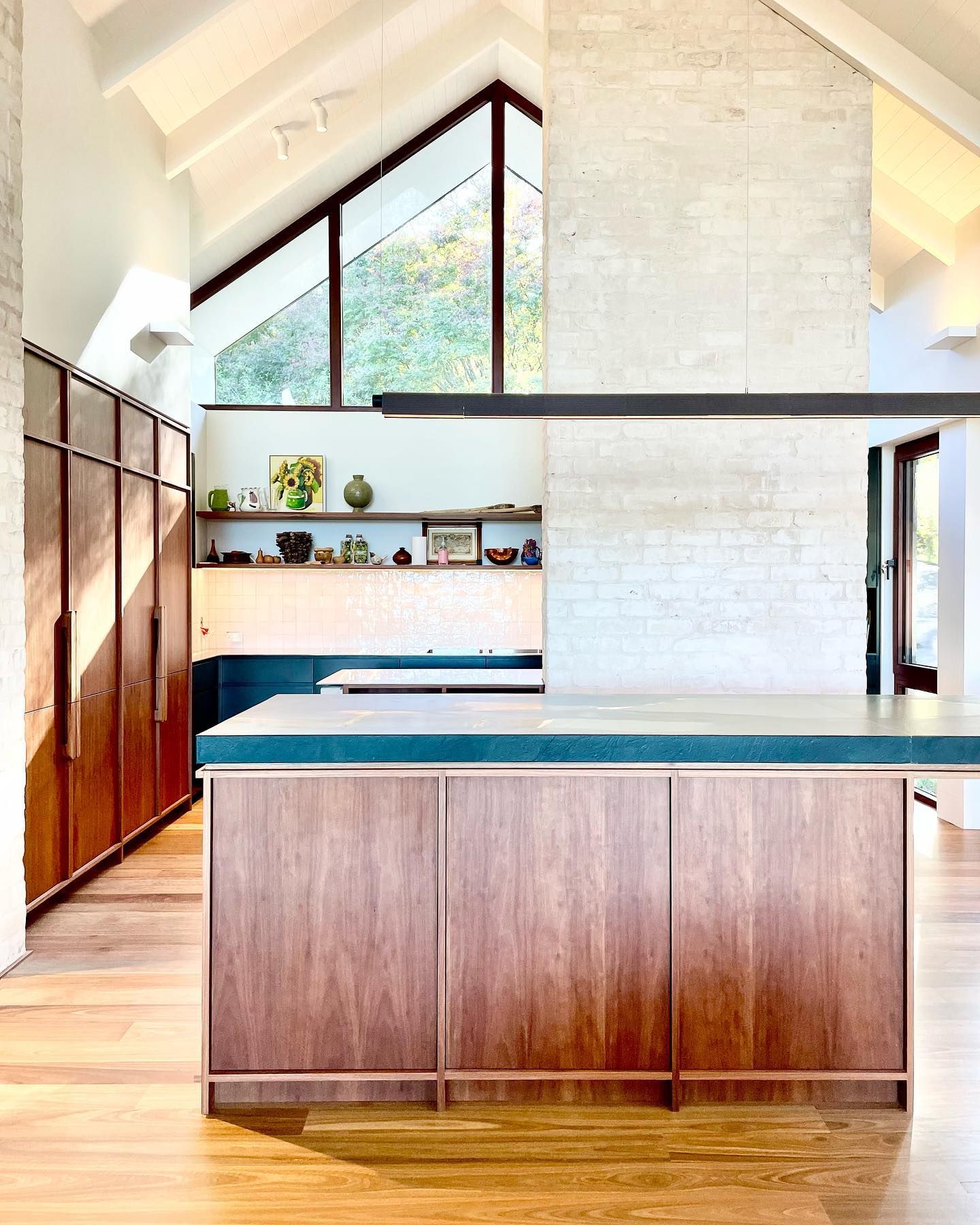 Modern kitchen with wood cabinetry, concrete accents, and a large window overlooking trees — BSpoke Cabinet Making & Joinery in Southerland Shire, NSW