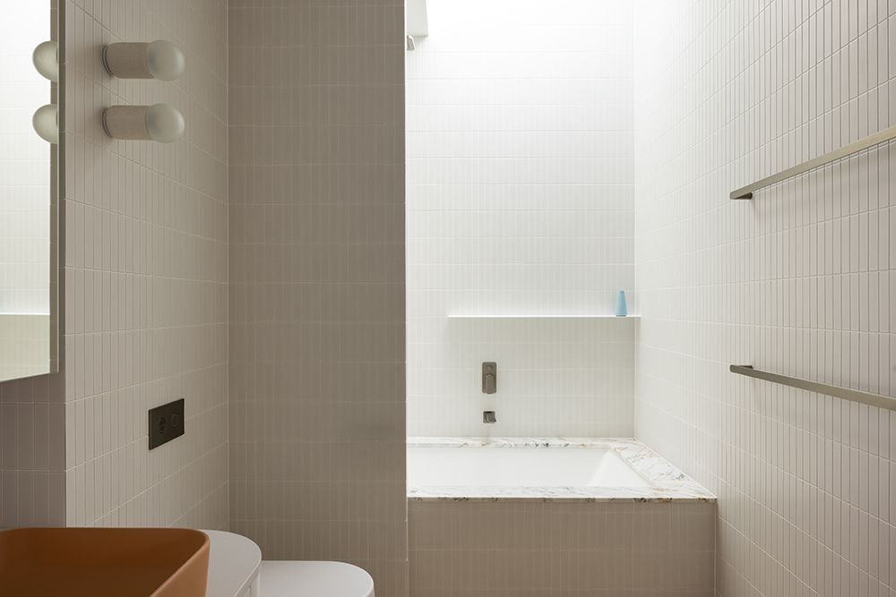 Small White Bathroom with a Bathtub, Toilet, and Two Towel Rails — BSpoke Cabinet Making & Joinery in Unanderra, NSW