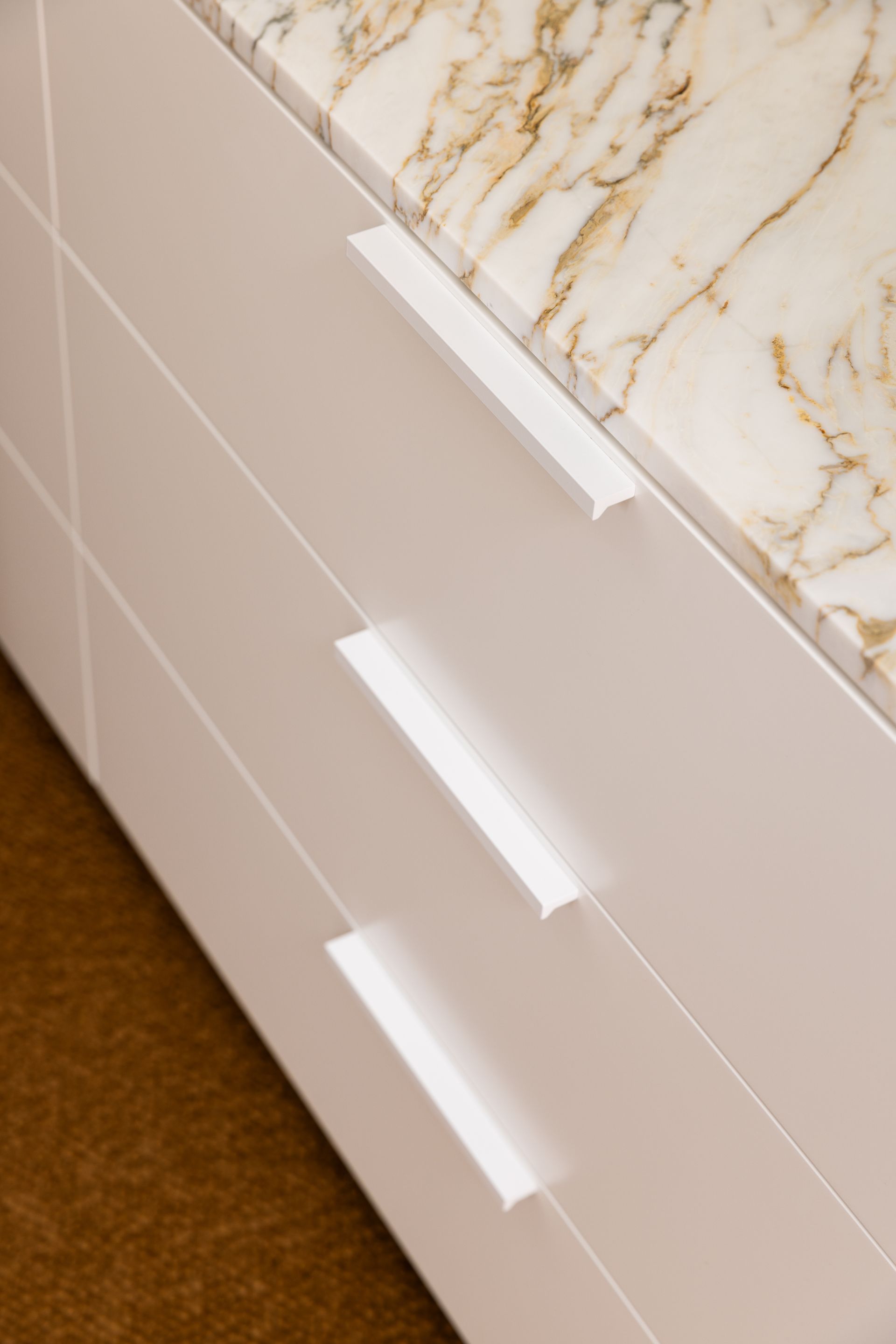 White drawers with white handles, beneath a marble countertop — BSpoke Cabinet Making & Joinery in Unanderra, NSW