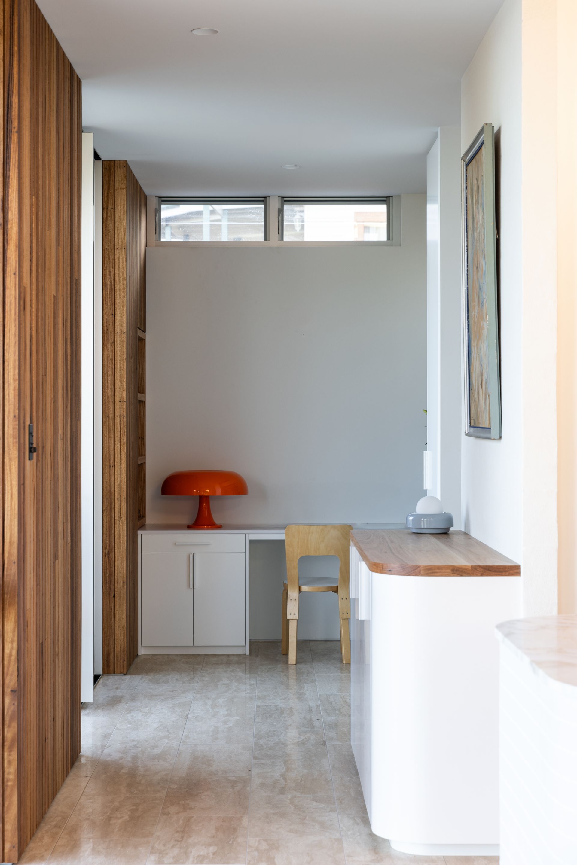 Hallway with desk, orange lamp, built-in storage, wood door, and artwork — BSpoke Cabinet Making & Joinery in Southerland Shire, NSW