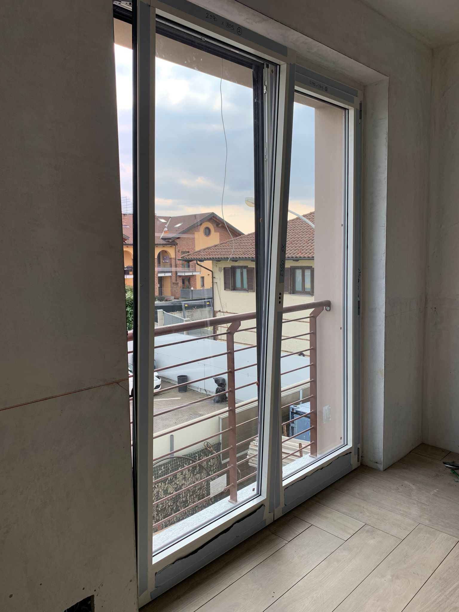 Una stanza con balcone e una grande finestra