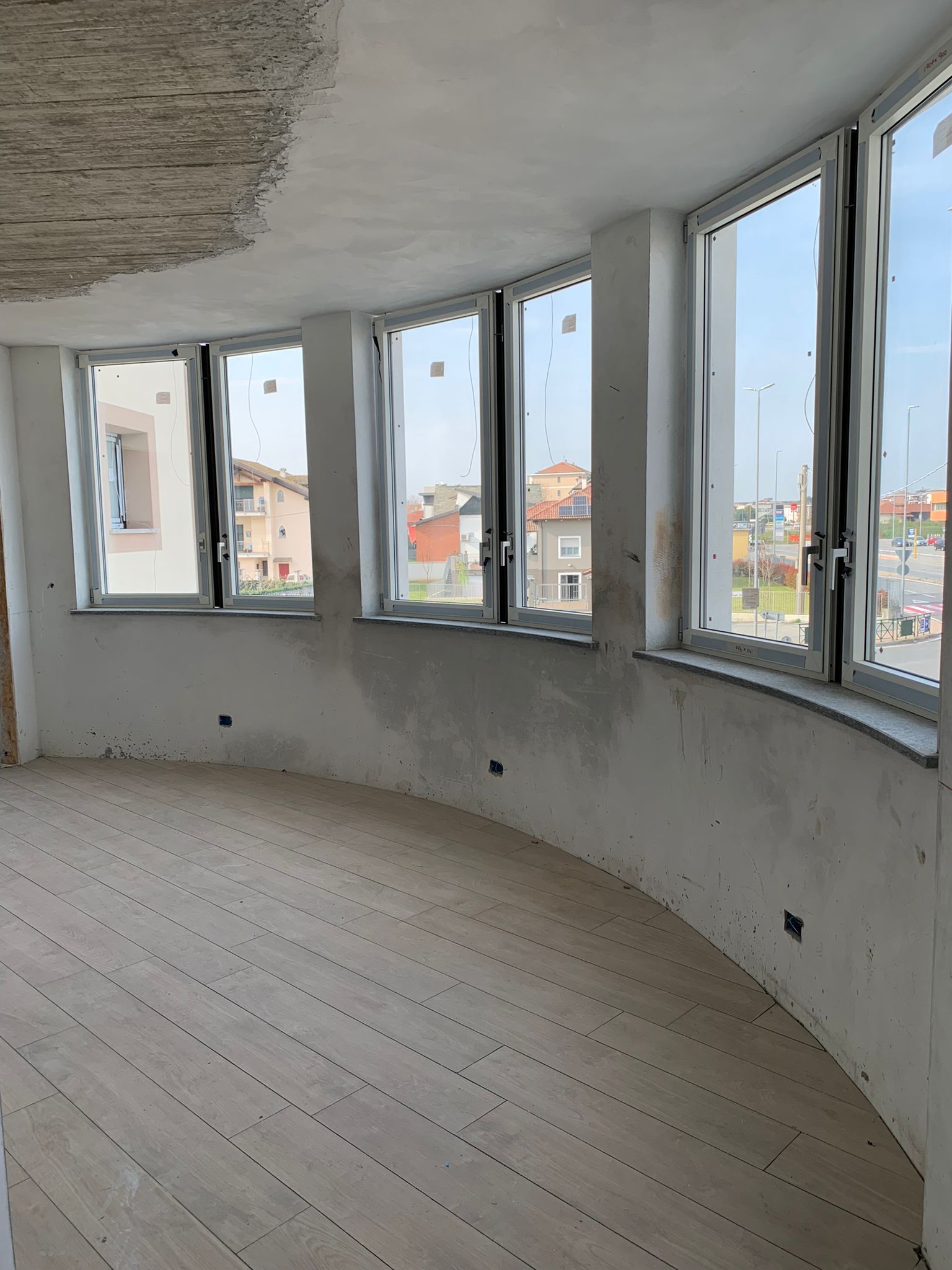 Una stanza con molte finestre e un pavimento in legno