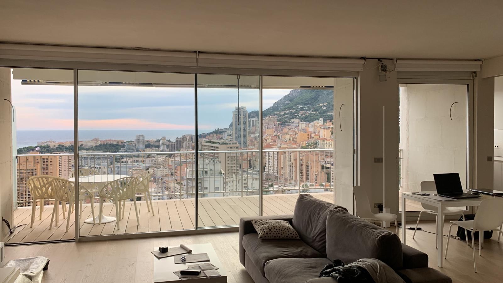 Un soggiorno con divano, tavolo, sedie e vista sull'oceano.