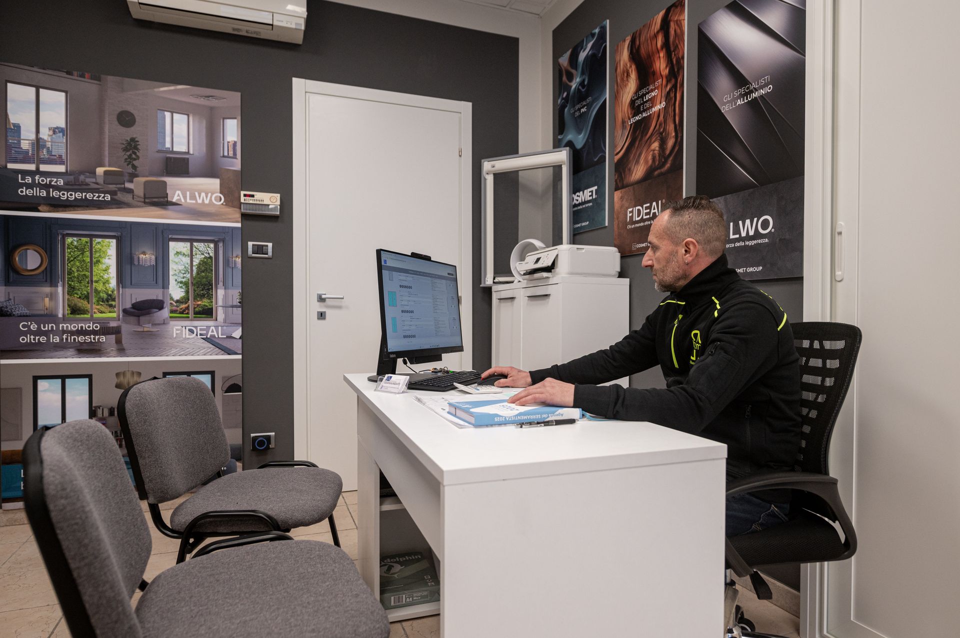 Un uomo è seduto alla scrivania davanti a un computer.