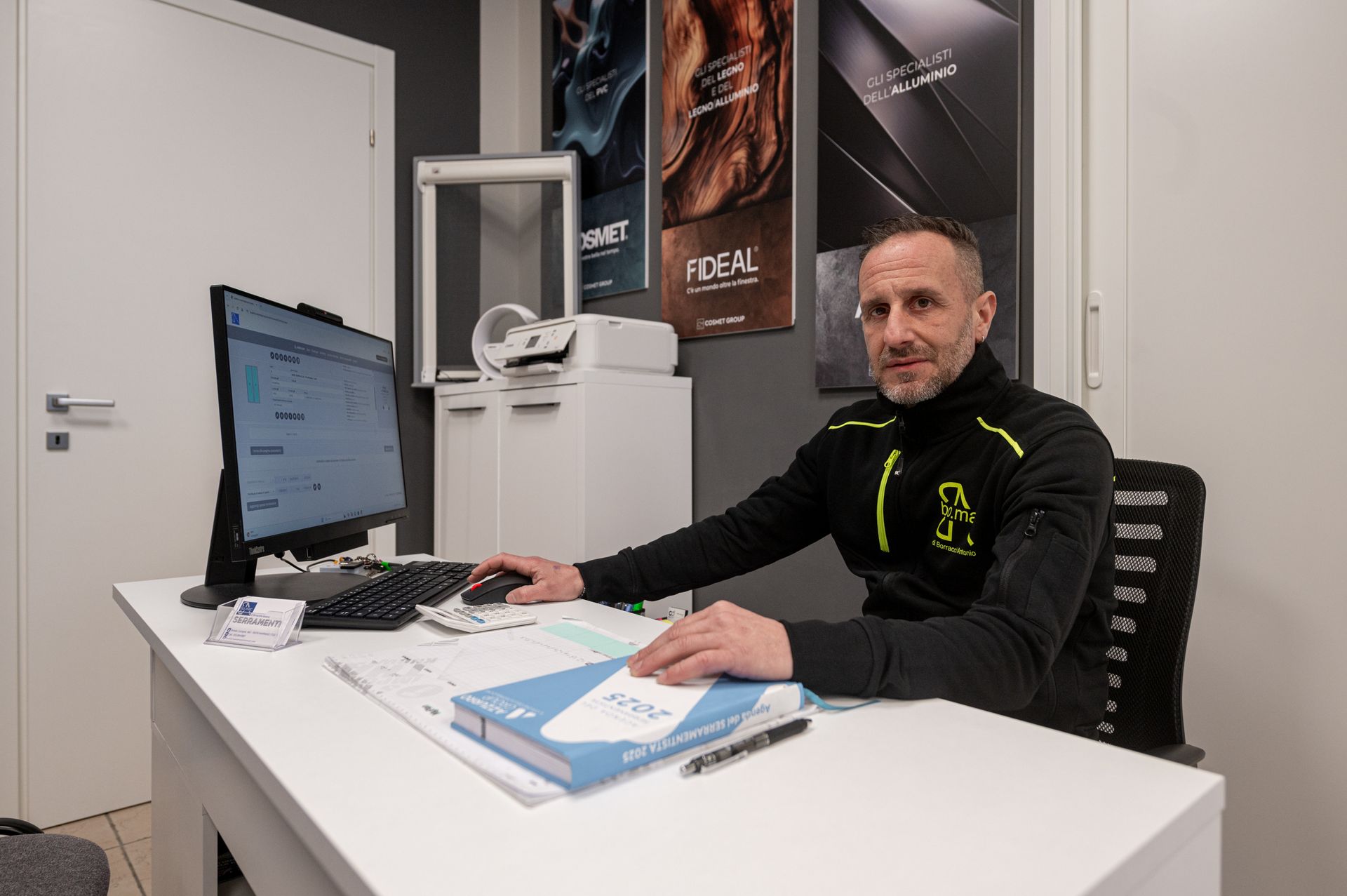 Un uomo è seduto alla scrivania davanti a un computer.