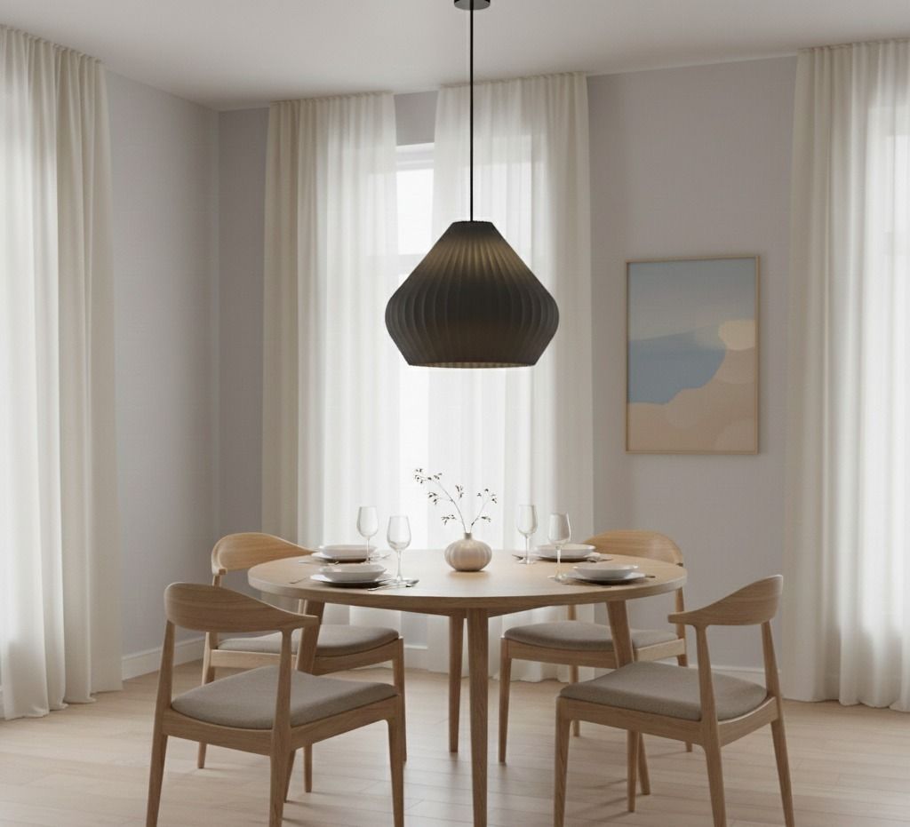 Comedor con mesa redonda de madera, sillas, lámpara colgante y cortinas transparentes.