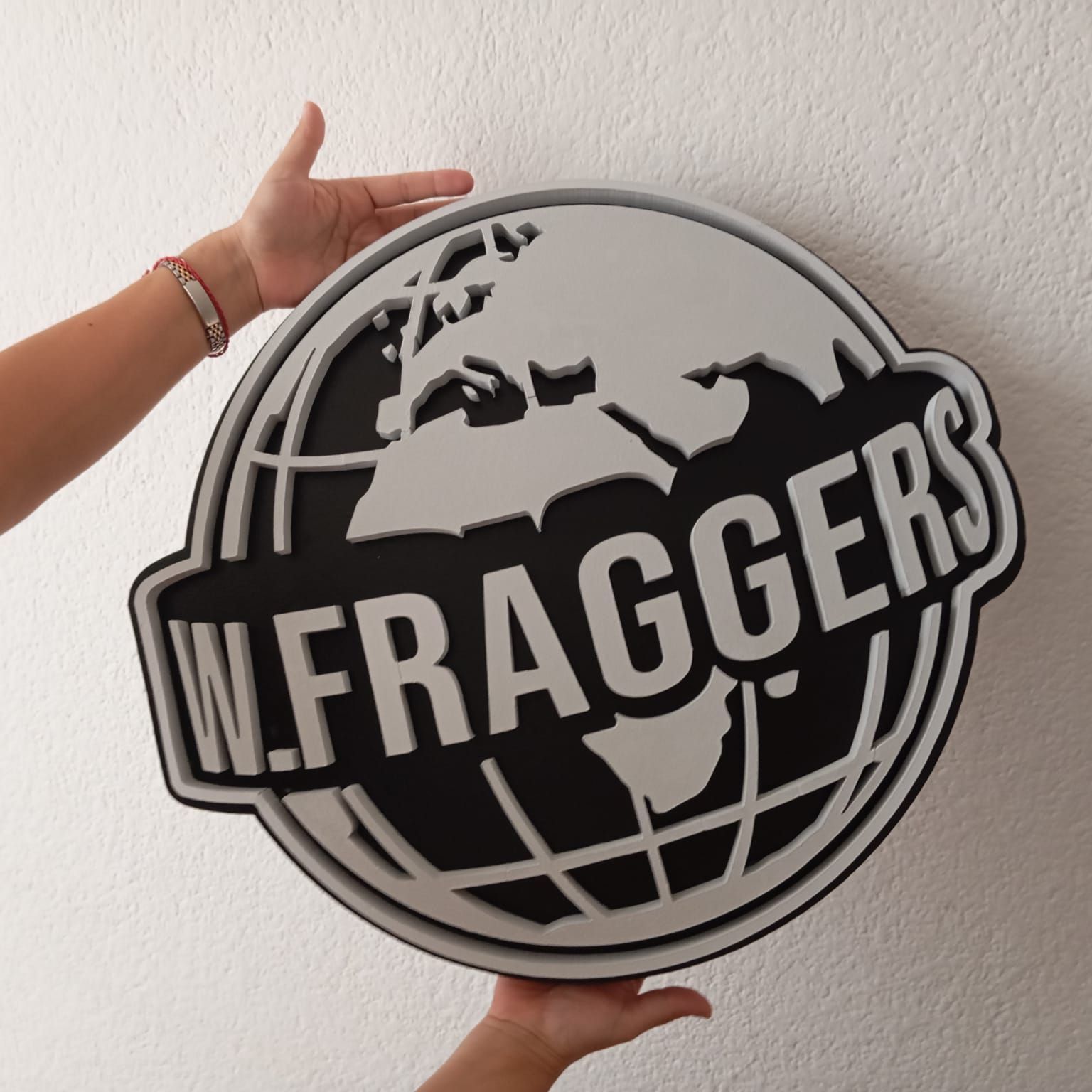 Una persona sostiene un cartel que dice W. Fragger's