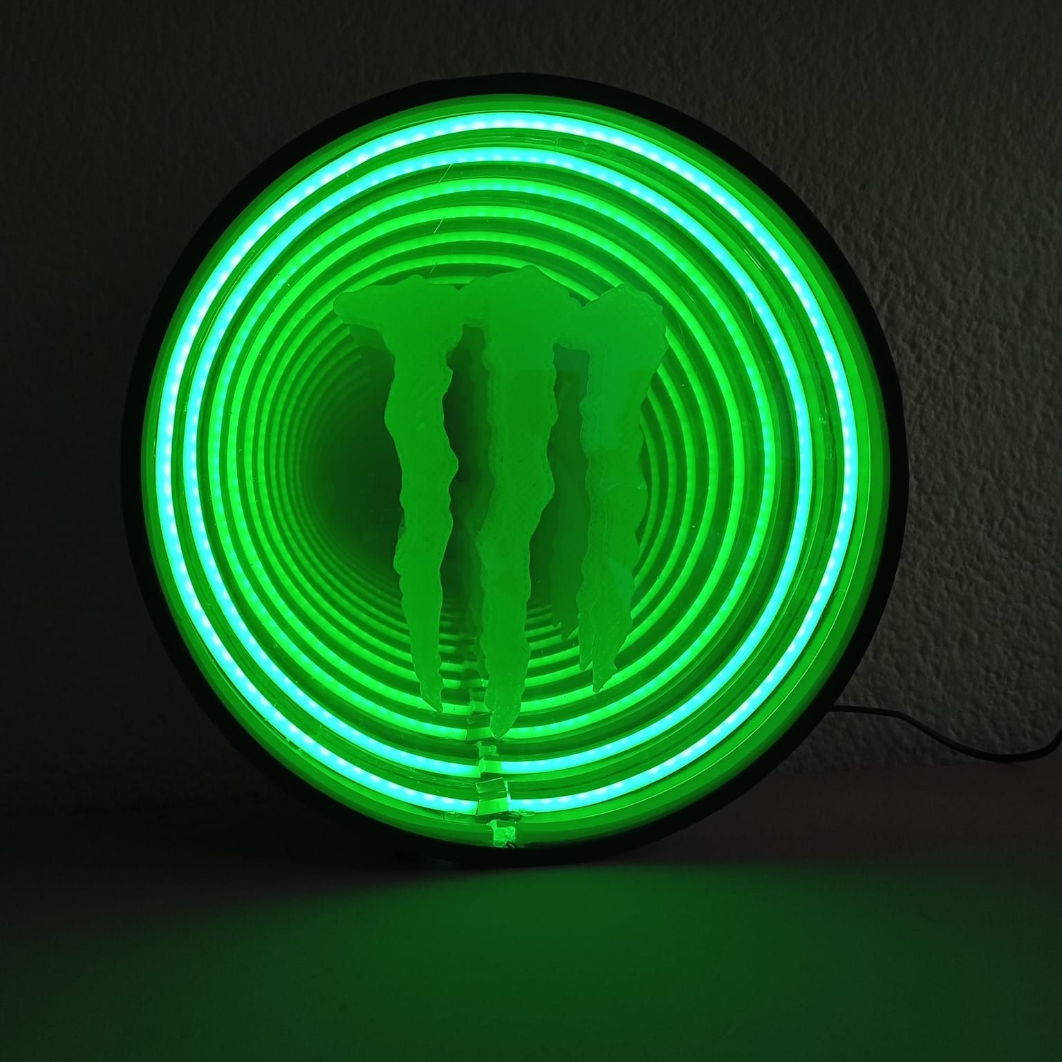 Un letrero de neón de Monster Energy brilla en la oscuridad.