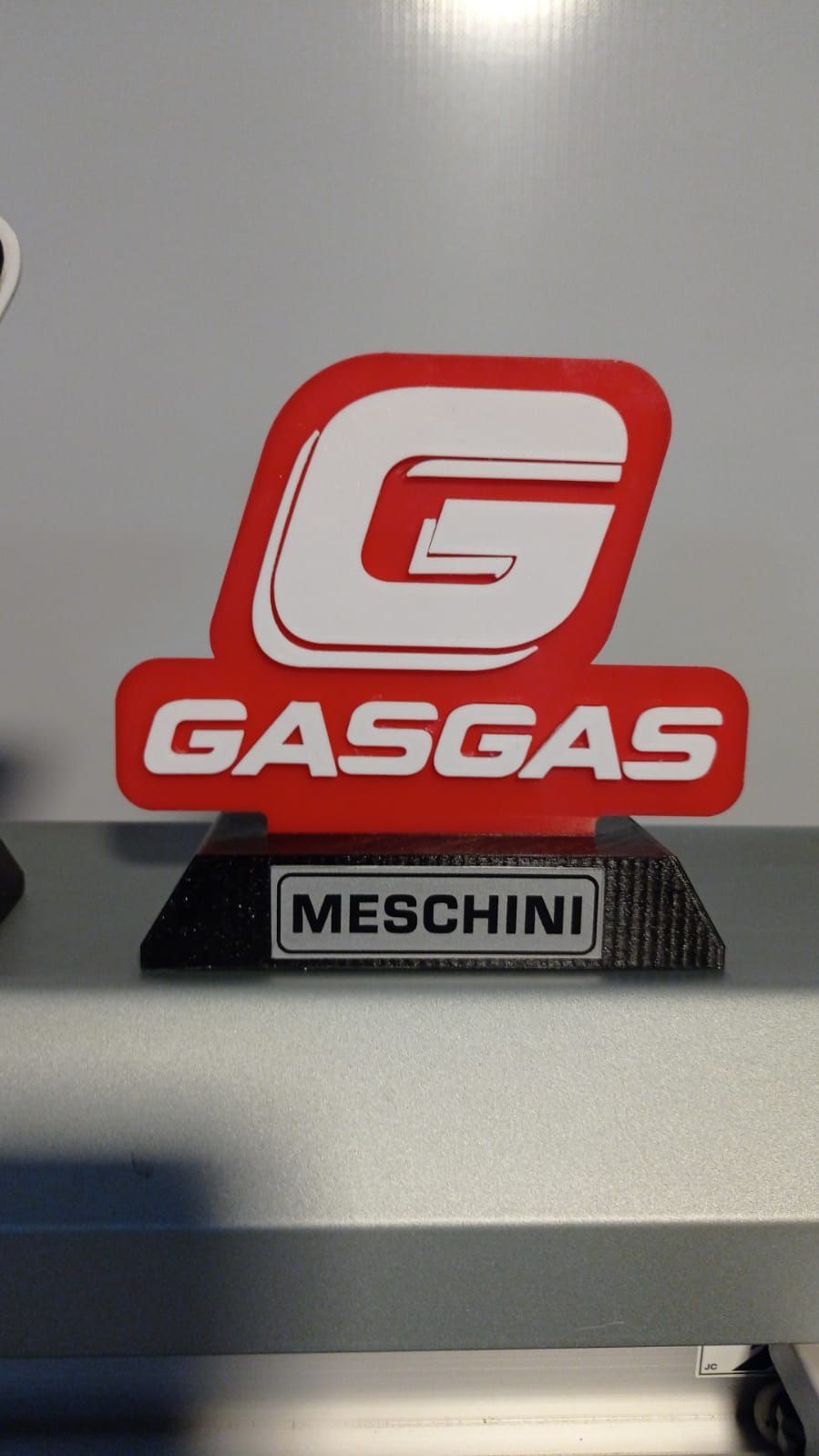 Fachada de heladeria colonial con letrero iluminado blanco sobre vitrinas. Sillas forradas en el interior.