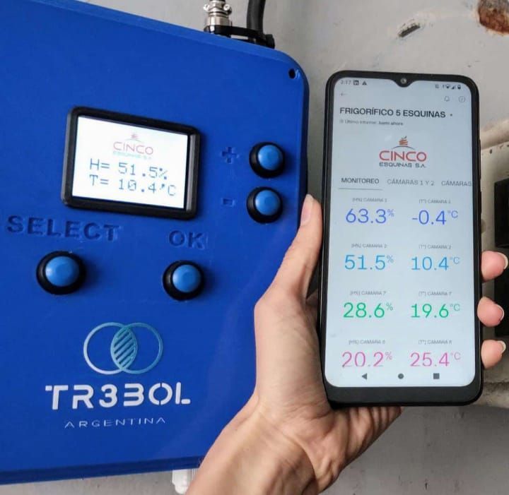 Una persona sostiene un teléfono frente a un dispositivo tr330l.