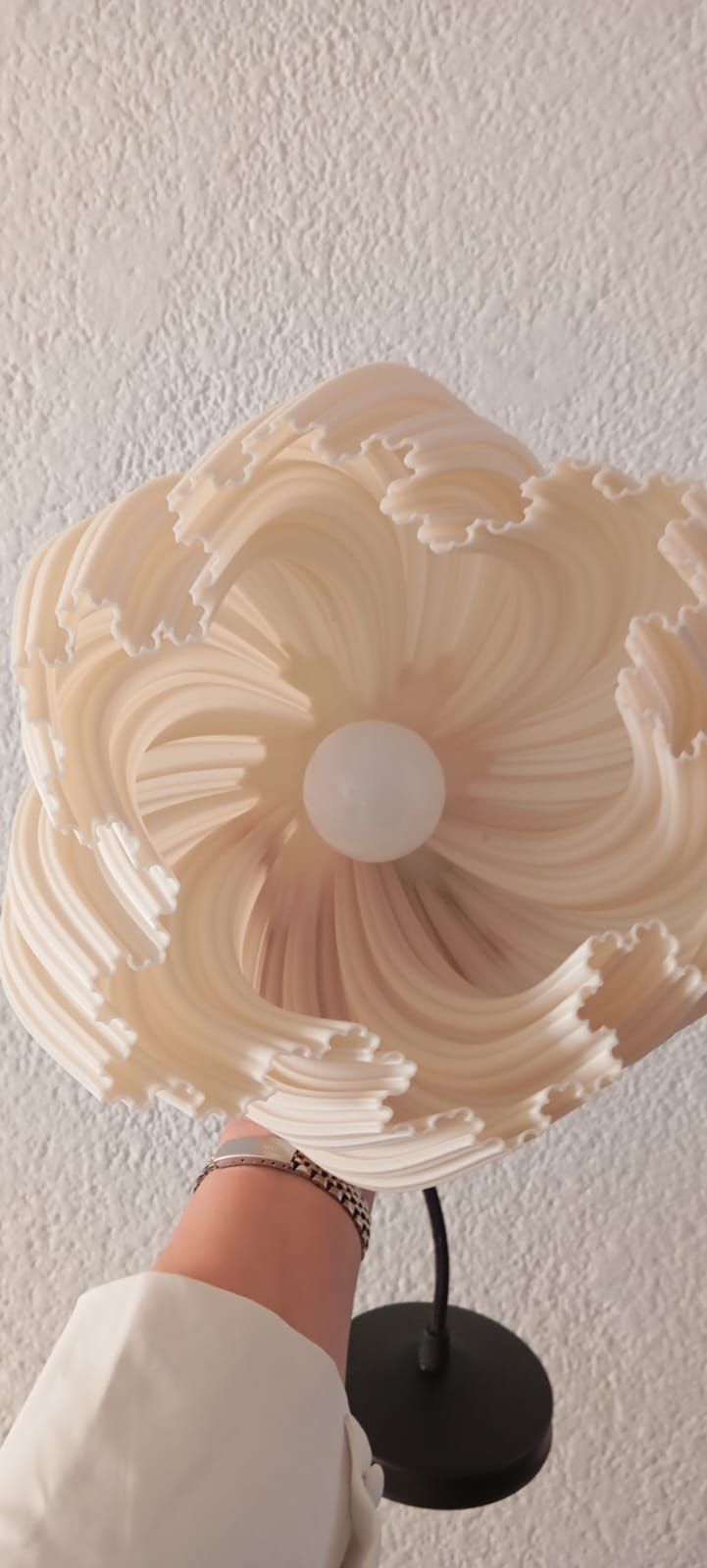 Una persona sostiene una pantalla de lámpara en su mano.