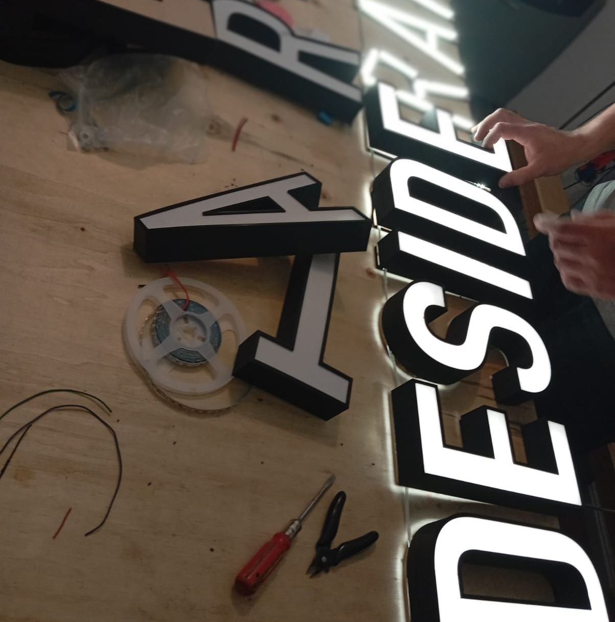 Una persona está trabajando en un cartel que dice afuera