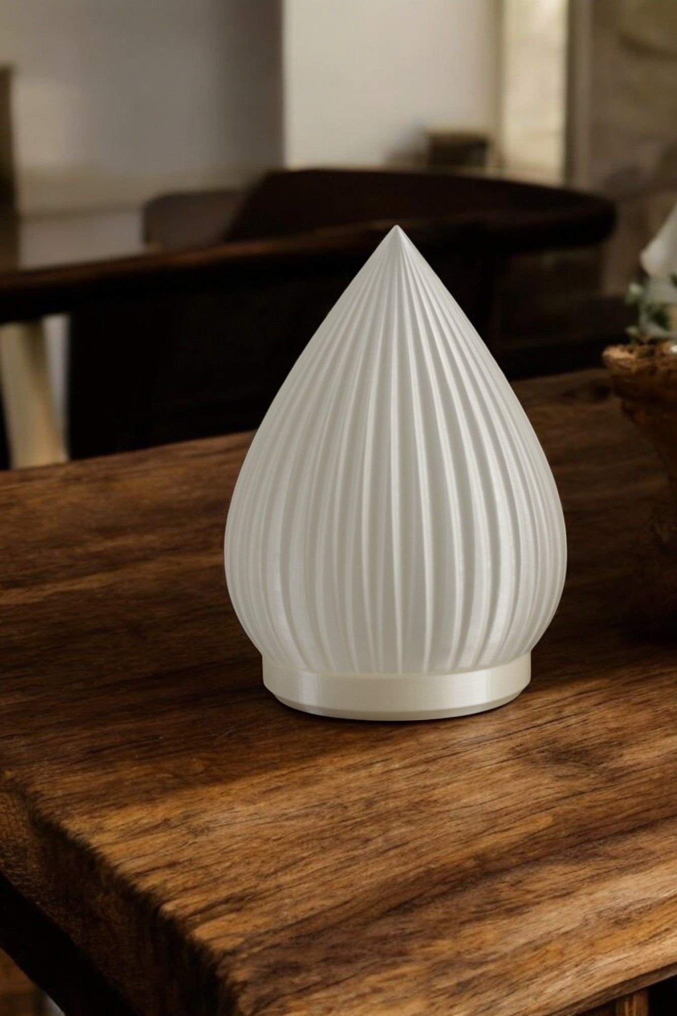 Una lámpara blanca está encima de una mesa de madera.