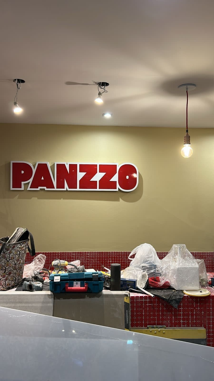 Interior de un restaurante en construcción con el cartel 