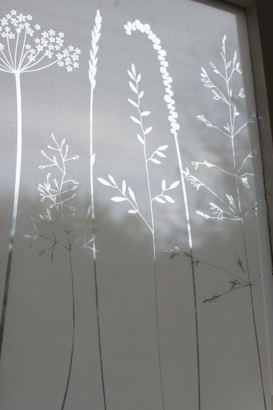 Ventana blanca grabada con delicados diseños vegetales.