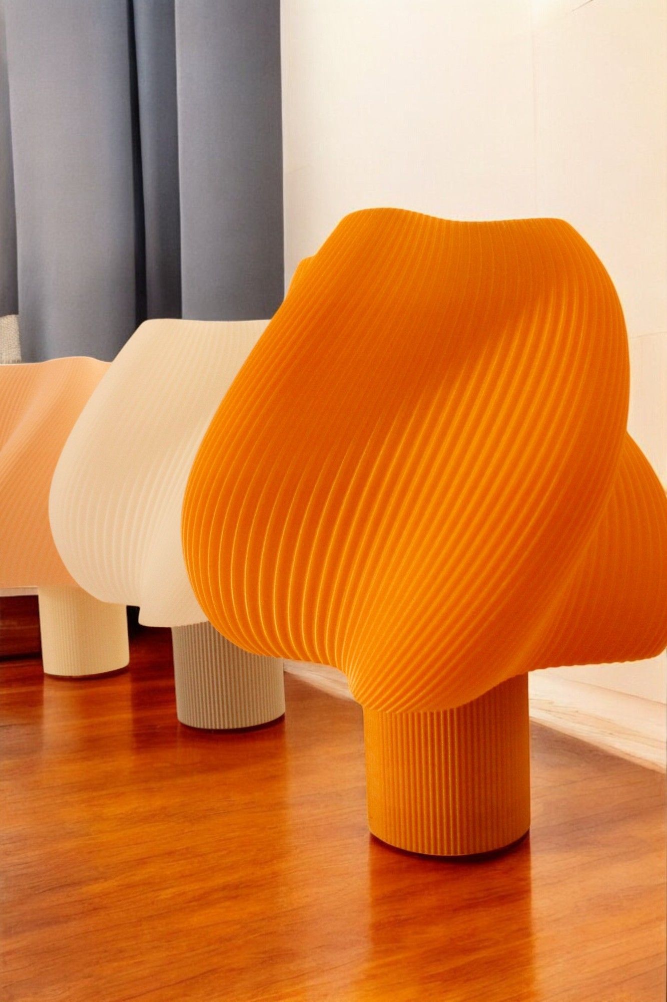 Una fila de sillas naranjas y blancas sobre un piso de madera.