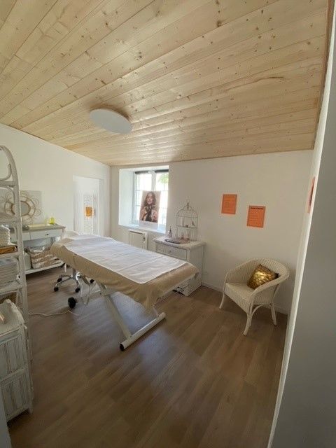 Une table de massage dans une pièce avec un plafond en bois