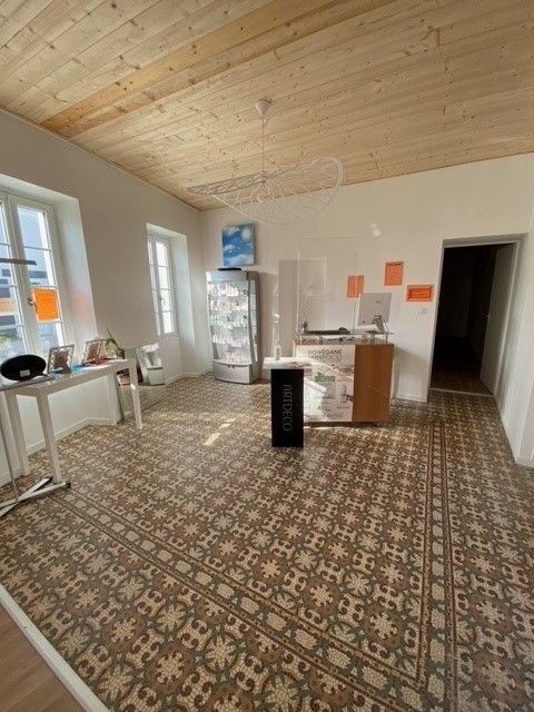 Une pièce avec un sol carrelé et un plafond en bois