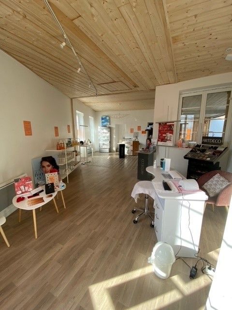 Une femme est assise à une table dans une pièce avec un plafond en bois.