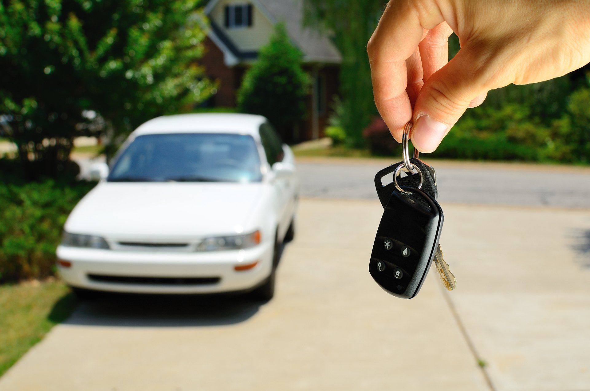 car in driveway holding up car keys