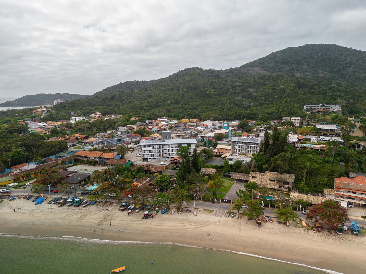 Uma vista aérea de uma praia com montanhas ao fundo.