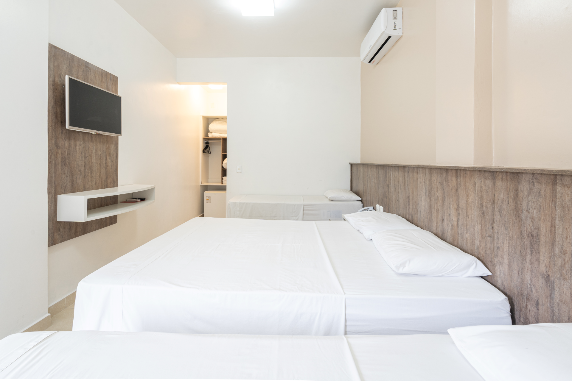 Um quarto de hotel com duas camas e uma TV de tela plana.