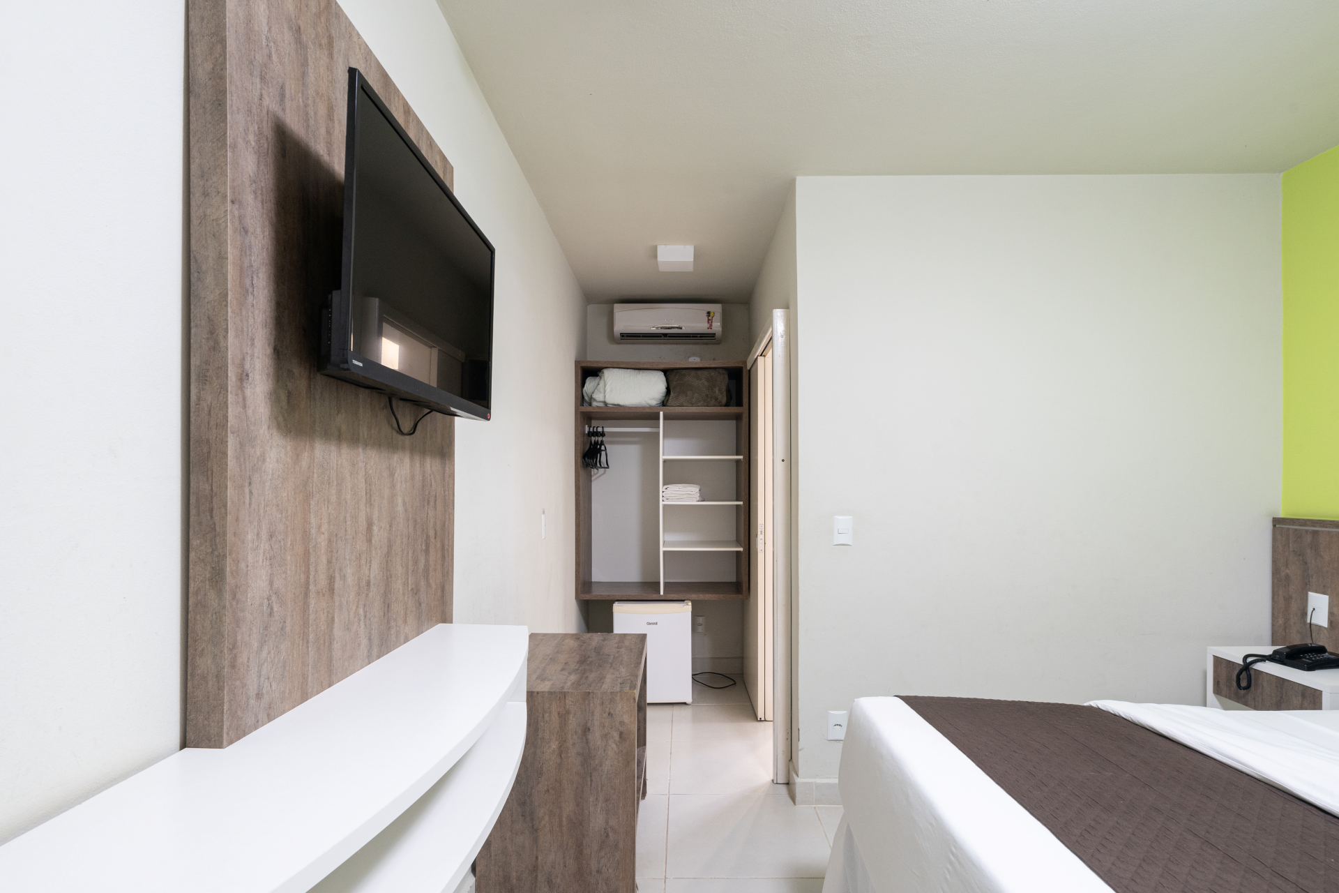 Um quarto de hotel com duas camas e uma TV de tela plana na parede.