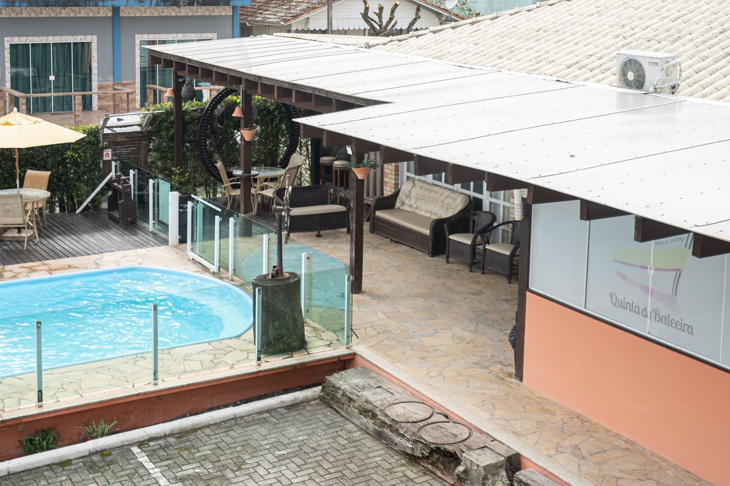 Uma vista aérea de uma piscina cercada por cadeiras e guarda-sóis.
