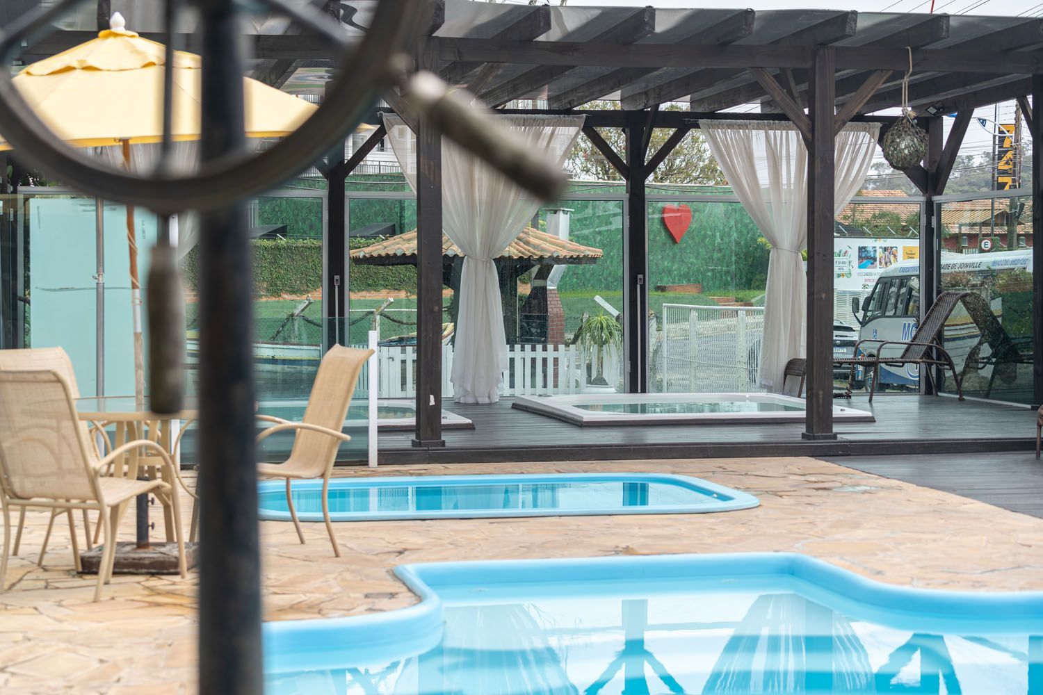 Uma piscina com cadeiras e guarda-sóis ao redor