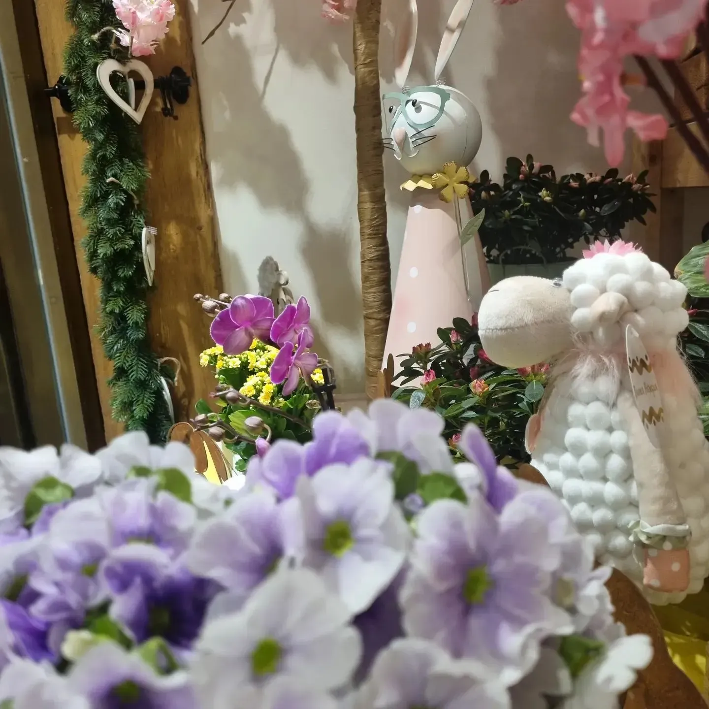 Un gruppo di animali di peluche è seduto davanti a fiori viola