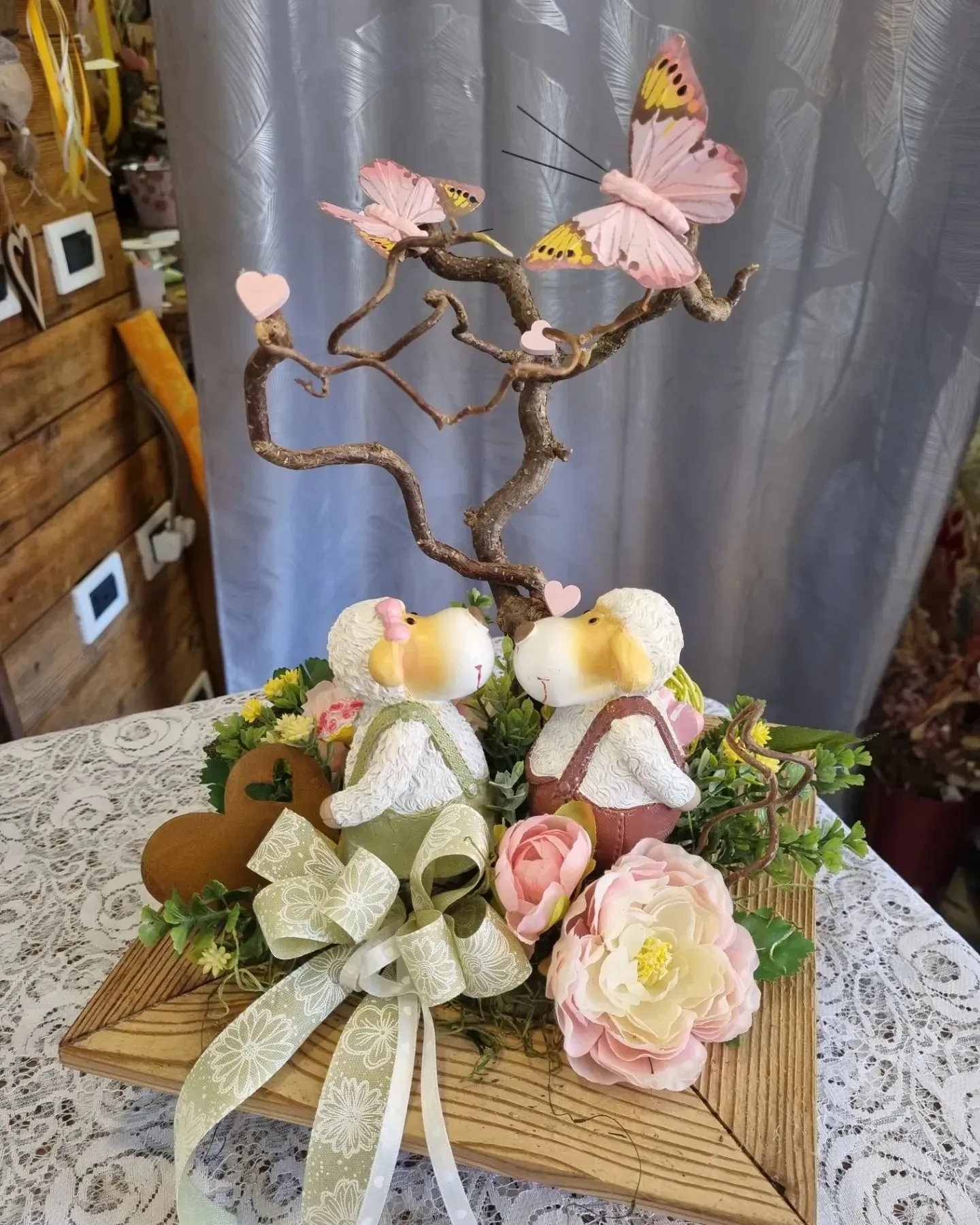 Una coppia di animali di peluche sono seduti sotto un albero con farfalle.