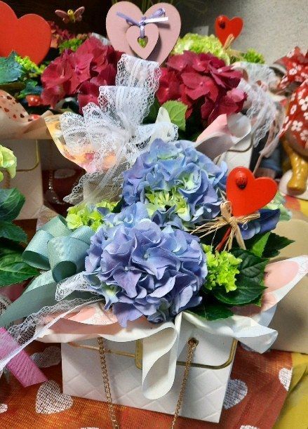 Un mazzo di fiori in una scatola con sopra dei cuori