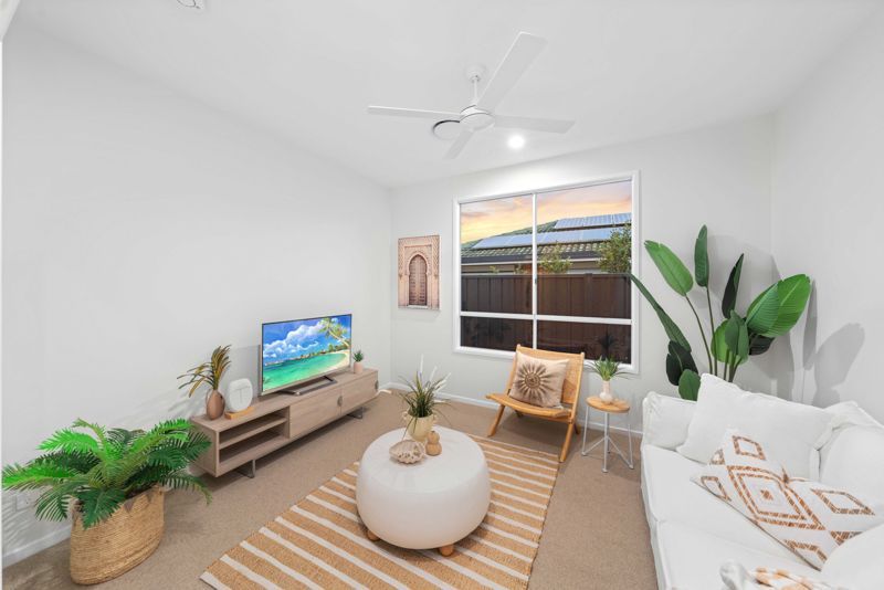 A living room with a couch , chair , table and television.