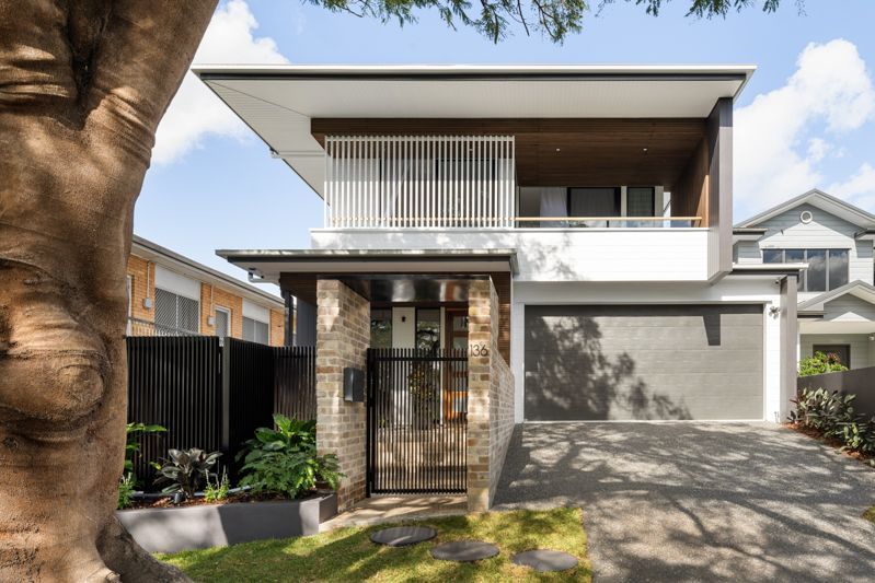 A modern house with a tree in front of it.