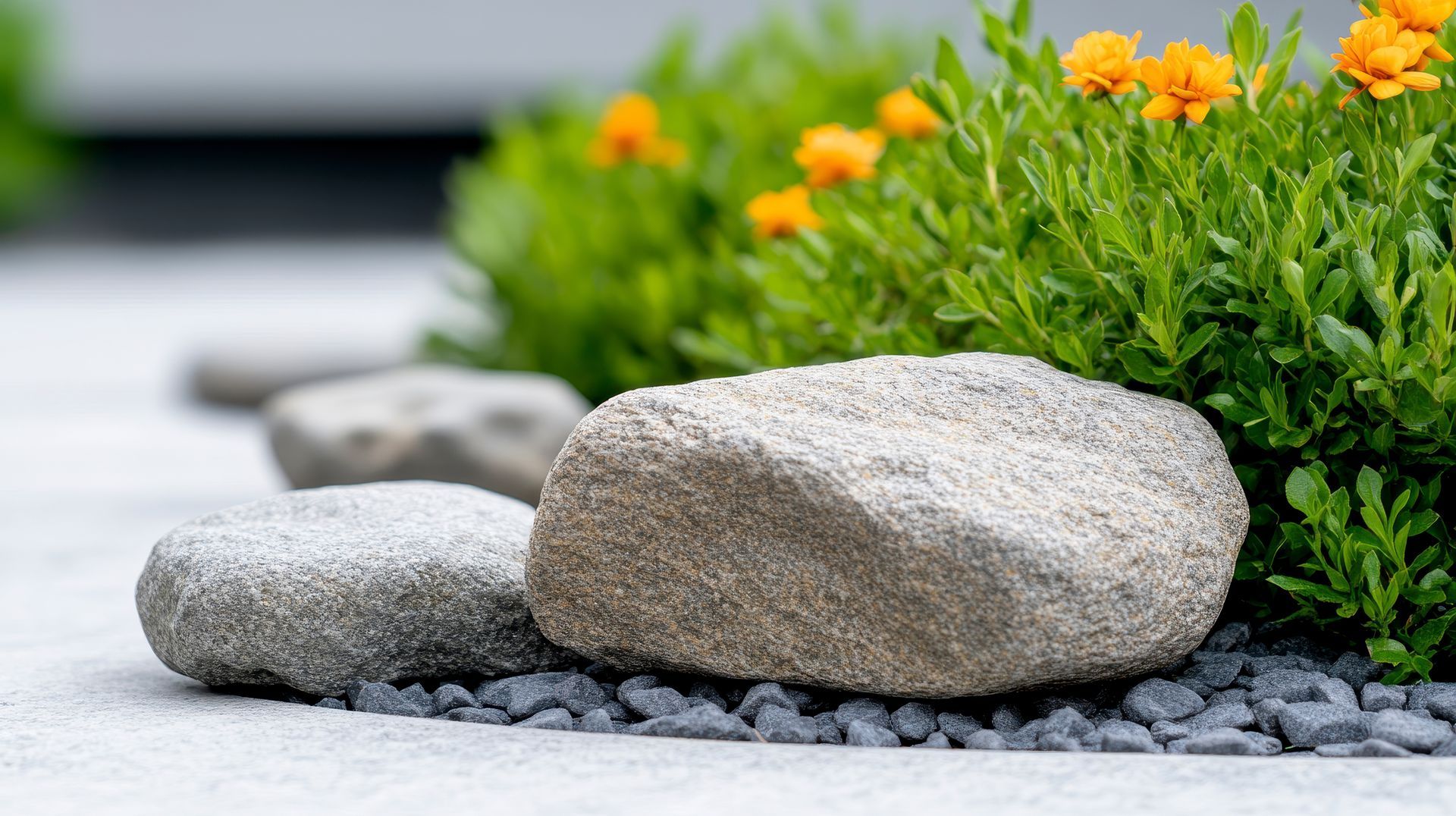Modern garden design featuring smooth grey stones and pebbles from a landscaping supply store.