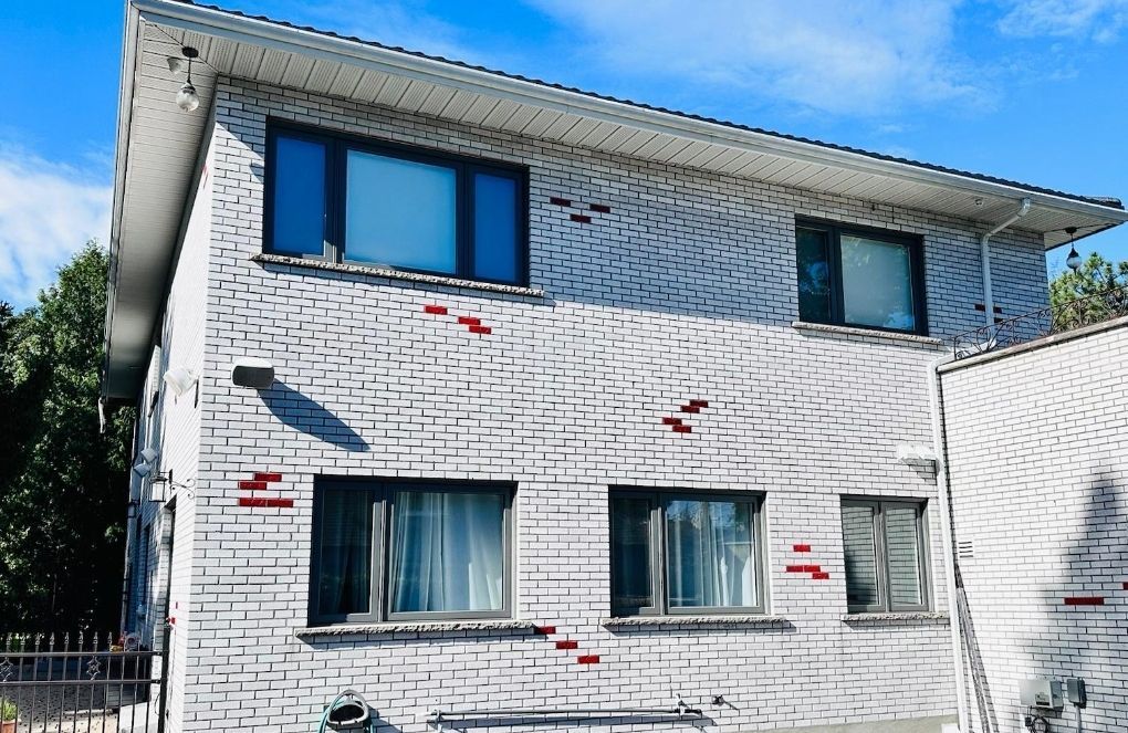 A white brick house with a blue sky in the background