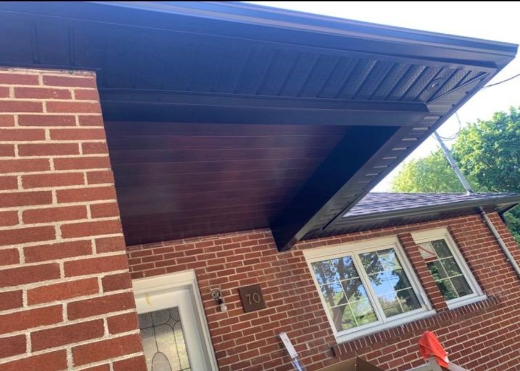 A brick house with a roof that is covered in wood.