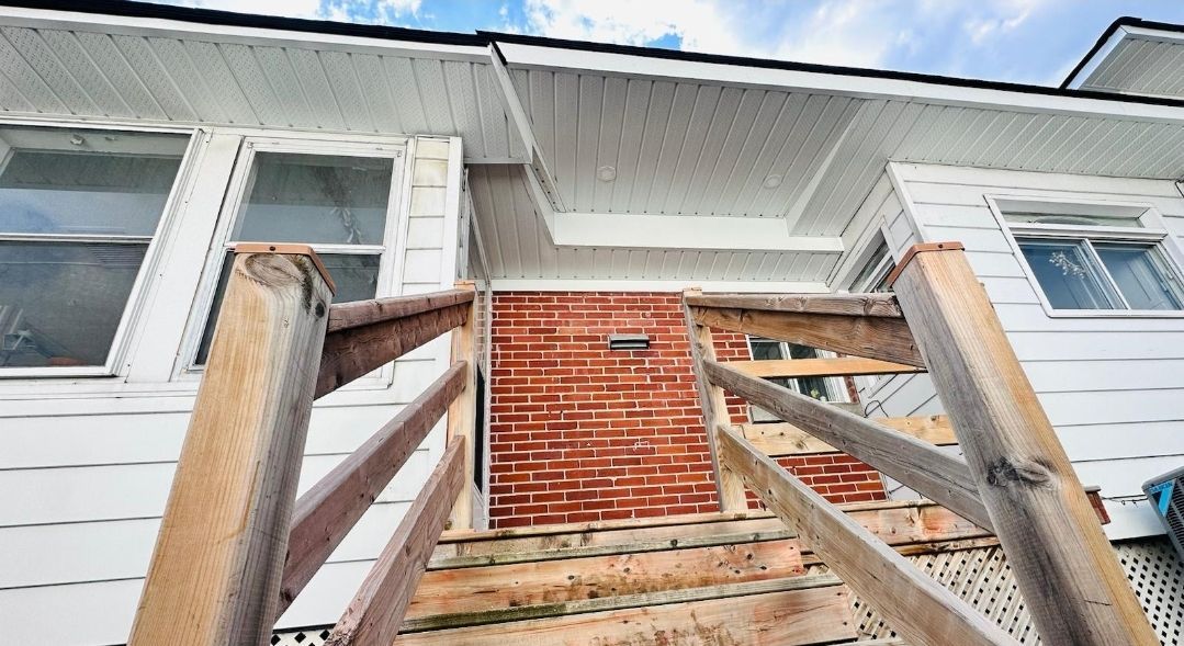 A house is being remodeled with wooden stairs and a brick wall.