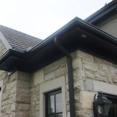 A house with a black gutter on the side of it.