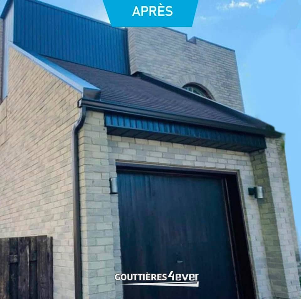 A brick building with a blue roof and a black garage door