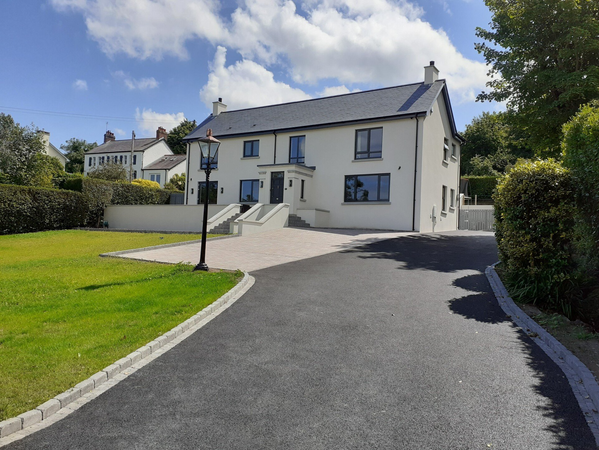 A large white house with a driveway leading to it