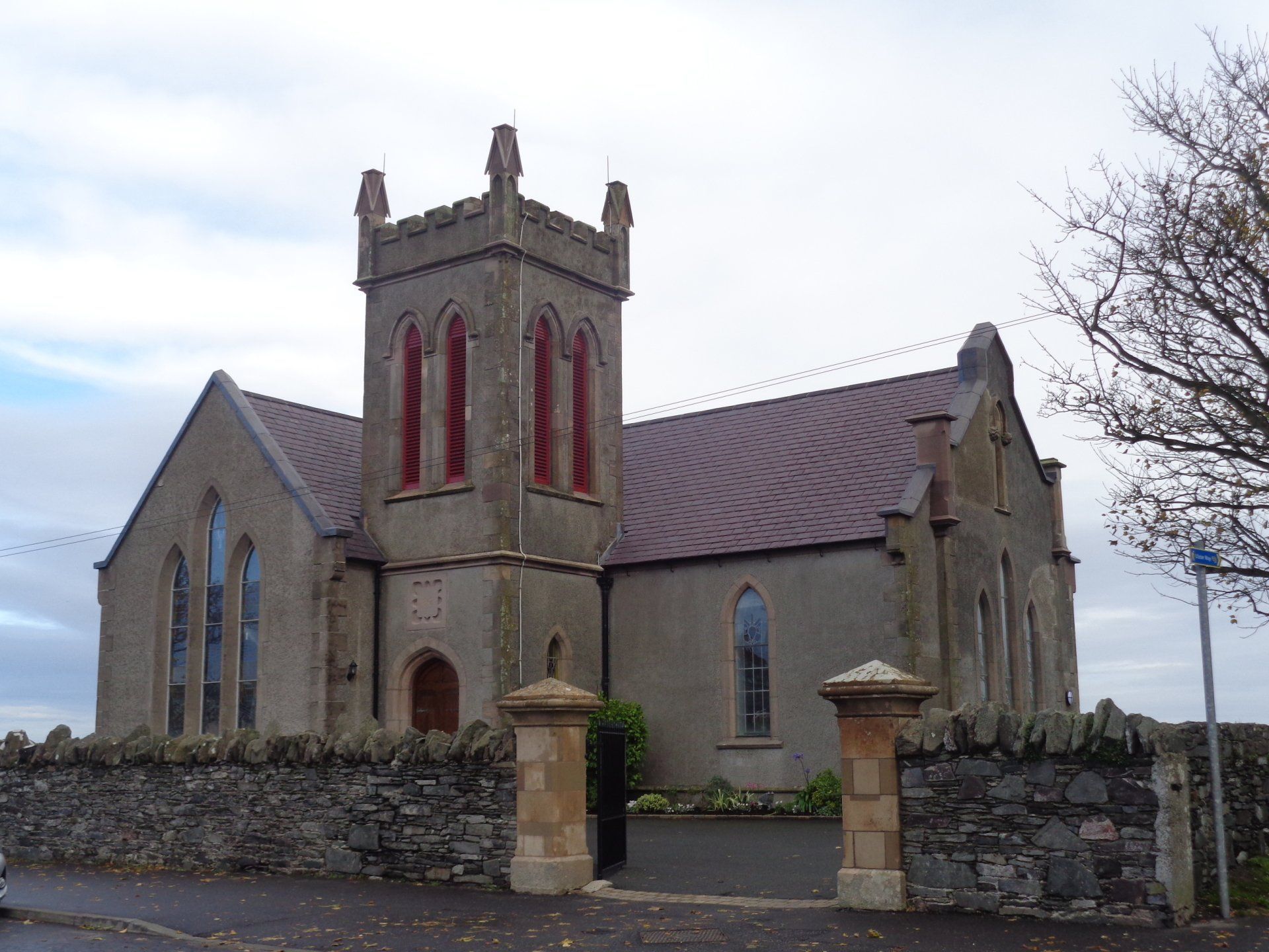 A church with a tower and a stone wall