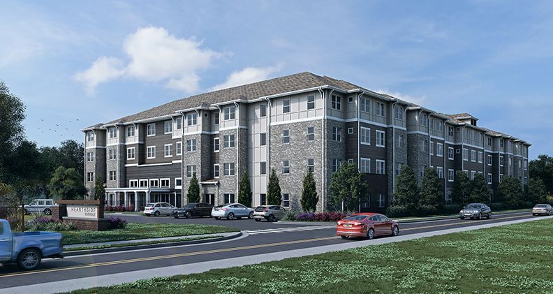 Exterior rendering of a multi-story assisted living facility with parking and street. Gray and tan building.