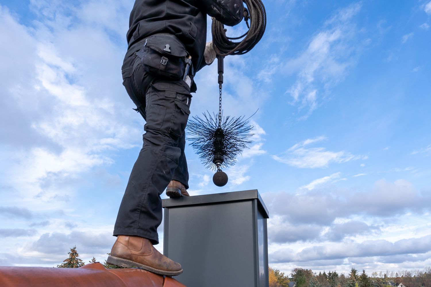 A man is cleaning a chimney with a brush.