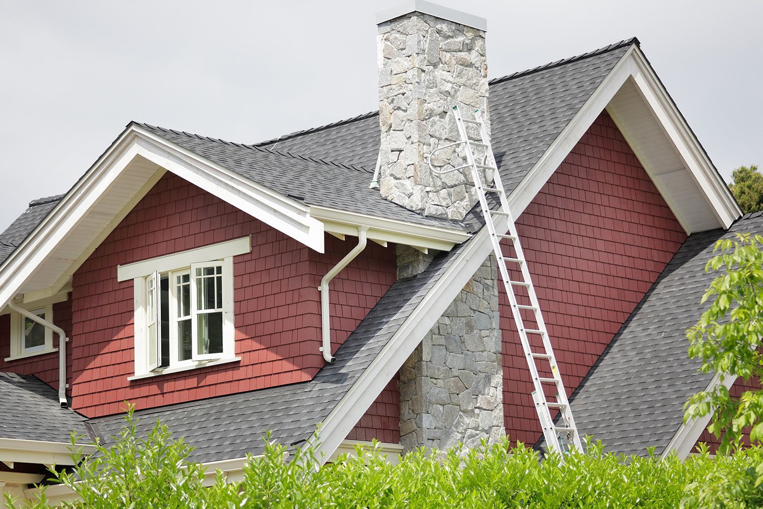 A ladder is sitting on the roof of a house.
