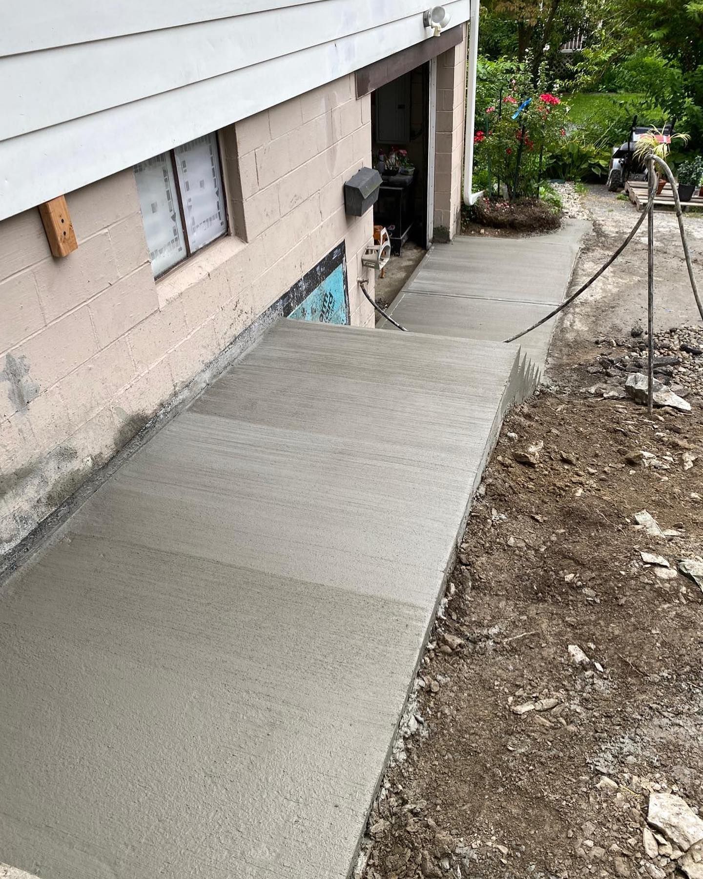 A concrete walkway is being built in front of a house.