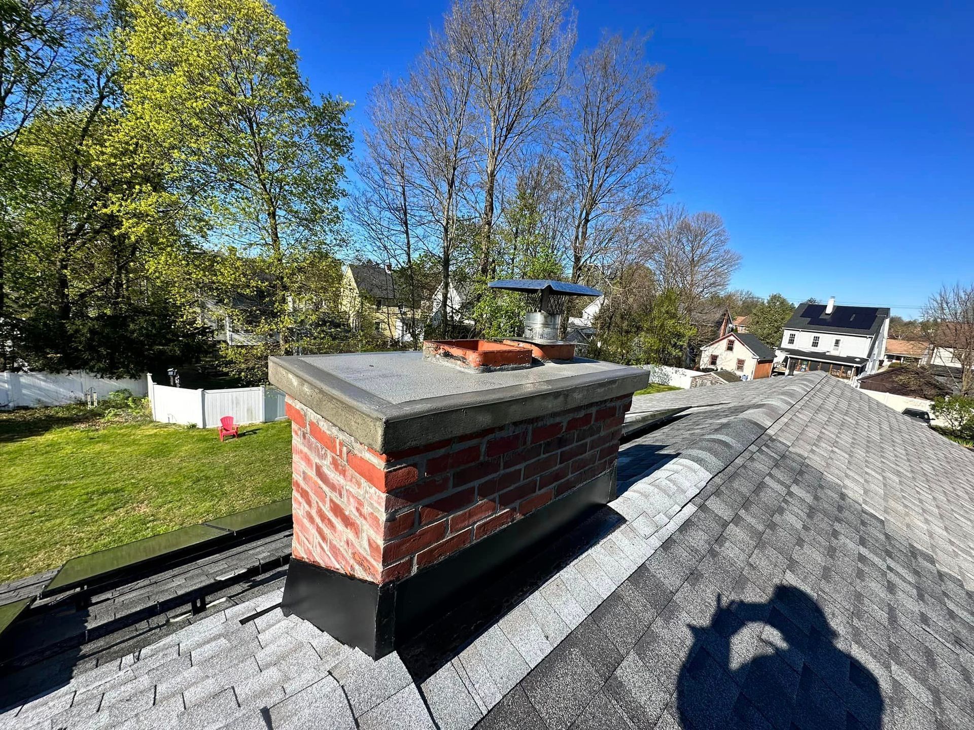 A brick chimney is sitting on top of a roof.